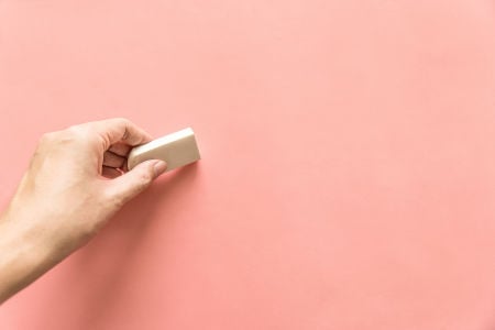a hand holding an eraser
