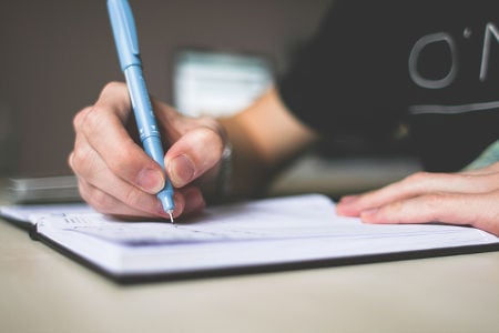 man writing on a notebook