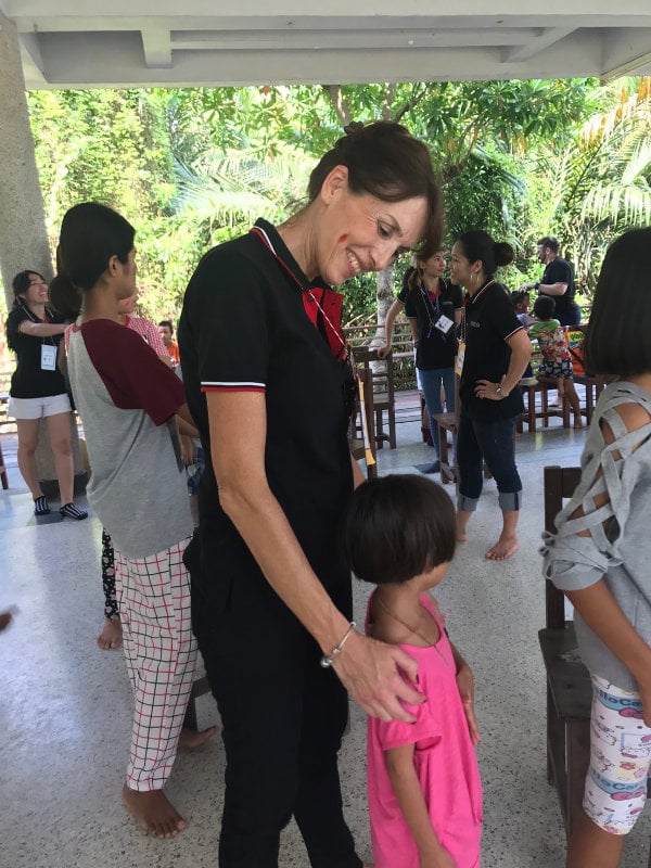 A Modulo French teacher smiling with a child from the orphanage